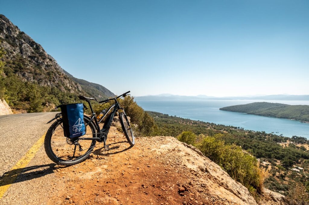 Bicycle parked on a cliff road overlooking the breathtaking Turkish coastline and blue sea.